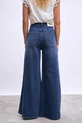 Pantalón de jean azul oscuro, modelo wide leg (pierna ancha) con tiro alto y cierre frontal de botones.
