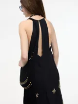 Vestido largo negro con breteles finos y bordado dorado.