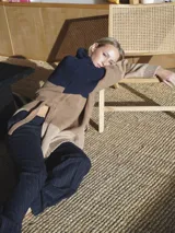 Buzo de punto grueso con bloques de color camel, azul marino y beige.