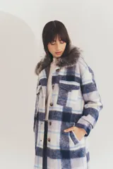 Tapado largo con estampado a cuadros en tonos marrón, beige y blanco. Presenta cuello con solapa y detalle de piel sintética.