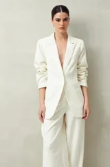 Blazer color crema a rayas verticales finas, de corte recto y solapas clásicas.