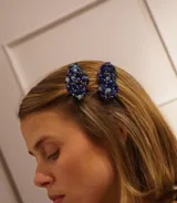 Par de hebillas para el pelo con cuentas azules y celestes.