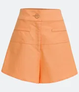 Short acampanado color naranja, de lino, con bolsillos y botón decorativo.
