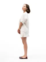 Shorts blancos de lino con cintura elástica completa y dos bolsillos laterales.