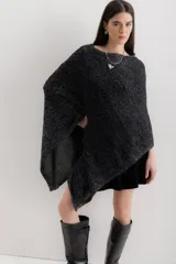Poncho negro con detalles en gris, de tejido de punto grueso y corte asimétrico.