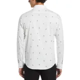 Camisa blanca de manga larga con estampado de palmeras y aves pequeñas en tonos naranja y azul. Tiene cuello abotonado, bolsillo en el pecho y corte clásico.