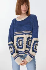 Sweater azul con cuello redondo y diseño de cuadrados de crochet en la parte inferior.