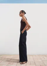 Pantalón de mezclilla (tejano) de tiro alto y corte wideleg, color azul oscuro. Presenta un diseño largo con terminaciones sin costuras y forro interior.