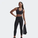 Calza deportiva 7/8 de compresión, color negro mate, con cintura alta y panel frontal liso. Presenta múltiples bolsillos laterales y traseros para guardar objetos.