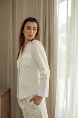 Pijama de algodón con camisa de manga larga abotonada y pantalón recto con elástico en la cintura.