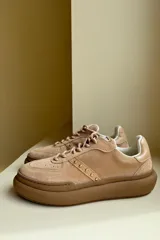 Championes urbanos blancos con detalles en gamuza color beige, cordones grises y suela gruesa.
