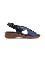 Sandalias color beige con tiras cruzadas en la capellada, una tira color dorado y otra color beige. Tiene una tira trasera con hebilla para ajustar al tobillo y suela baja.
