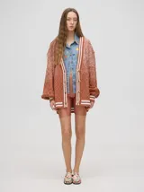 Cardigan tejido de punto con patrón de rombos en degradé de grises y blanco. Tiene corte oversize, mangas largas y cierre frontal con botones.