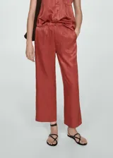 Pantalón color ladrillo de tiro alto, corte recto y tejido satinado.