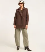 Saco alargado de polyvelour con textura boucle, cuello solapa, abotonado delantero y bolsillos. Forro de poliéster.