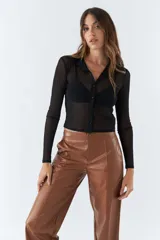 Camisa negra traslúcida de manga larga con cuello clásico y cierre frontal con botones.