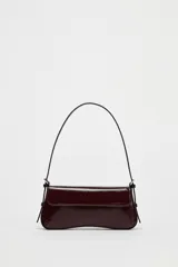 Bolso de hombro color borgoña con efecto acharolado, solapa con cierre magnético y asa ajustable.
