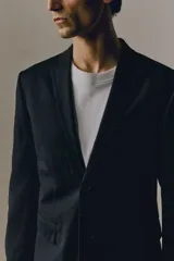 Blazer negro de corte slim fit, con solapas de muesca finas, ojal decorativo, botonadura sencilla, bolsillo superior insertado, bolsillos delanteros con solapa, dos bolsillos interiores, botones decorativos en los puños y abertura doble atrás. Forrado.