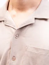 Camisa de manga corta color azul marino, confeccionada en tejido piqué de algodón. Presenta cuello cubano y cierre frontal de botones. Incluye un bolsillo de parche en el pecho izquierdo.