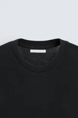 Camiseta marrón de punto, corte regular, cuello redondo y manga corta con terminaciones en rib.