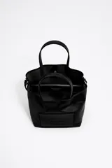 Bolso tote pequeño marca Bimba y Lola, modelo Chihuahua, color marrón. Confeccionado en nylon con estructura blanda, doble asa de mano y asa de tejido, piezas de piel, cierre con botón de presión, logo grabado, acabados metálicos, bolsillo interior e interior con placa metálica logotipada.