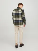 Sobrecamisa de manga larga a cuadros en tonos verde, azul y blanco. Tiene cuello clásico, cierre con botones, dos bolsillos en el pecho con botón y corte relajado.