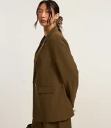 Blazer oversized color marrón con corte sastrero, solapas y cierre frontal con dos botones.