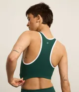 Top deportivo Get Over color verde con espalda nadador, escote en V, detalle de bies contrastante en blanco y copas removibles. Confeccionado en microfibra de poliamida y elastano.