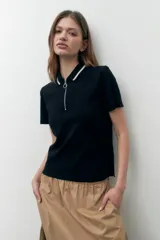 Remera de algodón color beige, con cuello polo y cierre frontal, de manga corta.