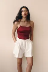 Short blanco de lino con cintura elastizada y cordón ajustable. Presenta pliegues frontales, bolsillos al bies y corte holgado.