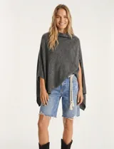 Poncho tejido de punto grueso, color mostaza/mostaza oscuro, con cuello redondo y caída amplia.