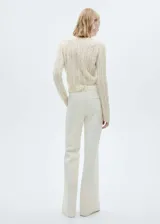 Sweater color crema de tejido de punto grueso con diseño trenzado y calado. Tiene cuello redondo y terminaciones acanaladas.