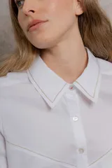 Camisa blanca de algodón con cuello tipo masculino, abotonadura central, manga larga y puños con botones. Canesú y cuello bordado con cadeneta a contratono.