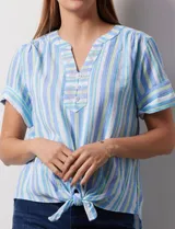 Blusa de algodón estampado a rayas verticales en tonos celeste, azul y verde. Tiene cuello a la base, escote en V con bordado y botones. Terminación de ruedo con nudo.