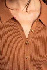 Cardigan negro de tejido de punto acanalado, con cuello polo, corte al cuerpo y cierre frontal con botones.