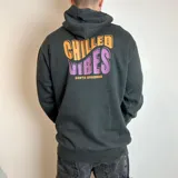 Canguro negro con capucha y estampado en la espalda con la frase "Chilled Vibes Santa Barbara" en colores naranja y violeta.