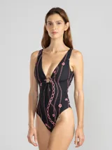 Malla entera negra con estampado de cadenas y flores rosadas. Presenta escote en V con abertura circular y breteles finos.