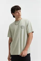 Remera de manga corta color verde claro con estampado de texto en el pecho, de corte oversize y cuello redondo.