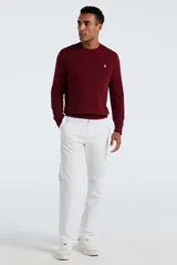 Sweater de punto liso color bordó, con cuello redondo y manga larga. Presenta un pequeño logo bordado en el pecho.