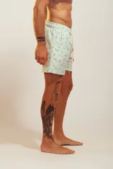 Bañador de hombre color rosa pálido con estampado de golondrinas oscuras. Presenta cintura elástica con cordón ajustable de color crudo y terminales turquesa.