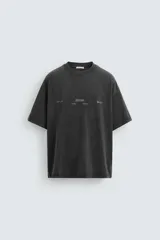 Camiseta negra de corte relaxed fit, cuello redondo y manga corta. Tiene un texto en relieve combinado a contraste en el delantero y efecto lavado.