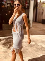 Top tejido en lurex color gris, con escote en V y flecos en el ruedo.