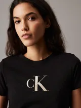 Remera negra de corte slim con cuello redondo y mangas cortas. Estampado frontal con el logo de Calvin Klein en color dorado.