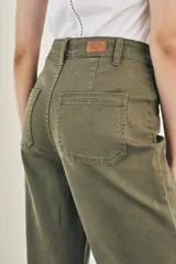 Pantalón wide leg color beige, de tiro alto, ligeramente ajustado en cintura y con ruedo desflecado.