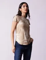 Remera de modal color beige con estampado de hojas blancas, cuello redondo y mangas cortas.