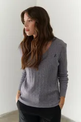 Sweater de punto marrón con escote en V y mangas largas.