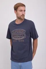 Camiseta azul marino de manga corta y cuello redondo con estampado frontal en color dorado que dice 'Superior Quality D.N.M. Jack & Jones Denim Company Est. 1990'.