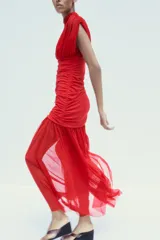 Vestido midi rojo de tul con cuello alto y mangas sisa semitransparentes. Interior con escote pico y tirantes finos ajustables. Tejido combinado a tono, detalle de frunces y cierre lateral con cremallera oculta.