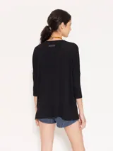 Remera negra de punto liviano con escote en V, mangas 3/4 y recortes diagonales en el delantero.