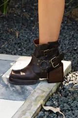 Botas cortas color gris con efecto desgastado, con hebillas doradas y taco cuadrado.